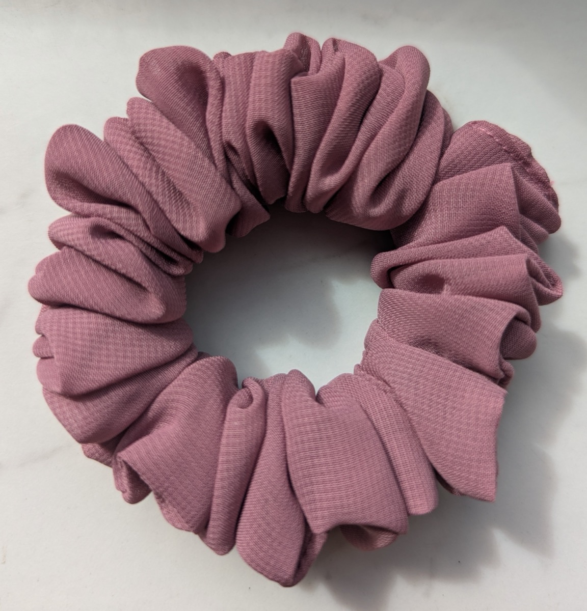 Handgenähter Scrunchie in Altrosa, auf hellem Untergrund fotografiert