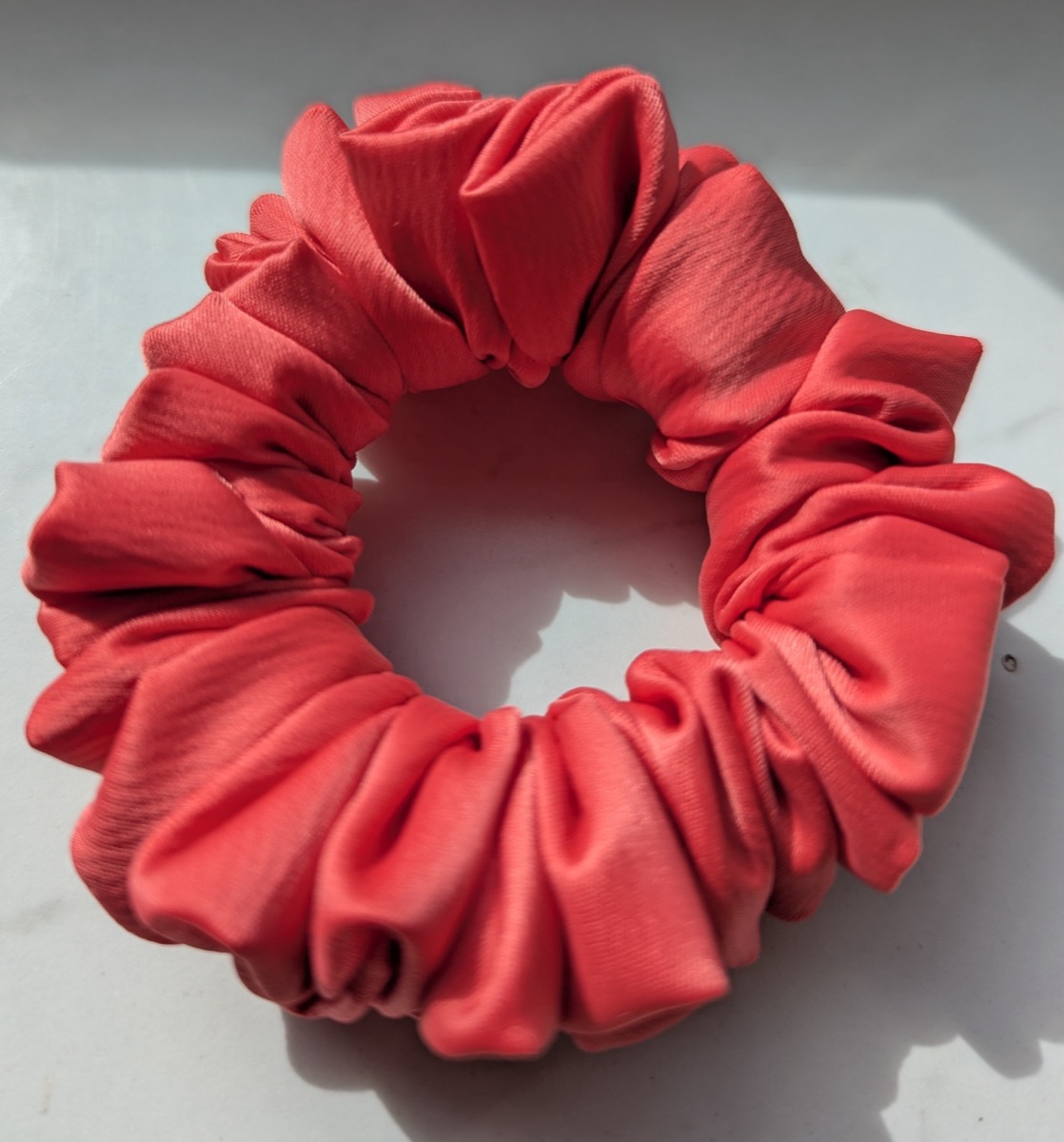 Handgenähter Scrunchie in Rot, auf hellem Untergrund fotografiert