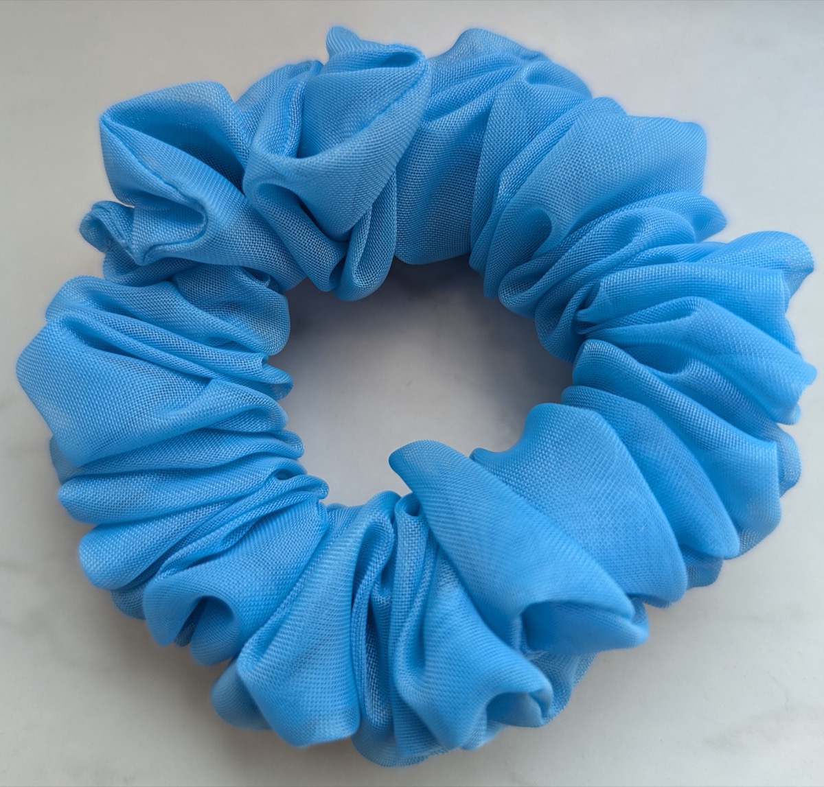 Handgenähter Scrunchie in Blau, auf hellem Untergrund fotografiert